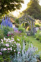 Shortly after dawn on a misty morning in the Sundial Garden at Wollerton Old Hall Garden, Wollerton, Shropshire - featuring David Austin roses, Stachys, Delphiniums, Dahlias, Phlox paniculata, Salvia microphylla and Knautia, among a wide range of other herbaceous plants. 