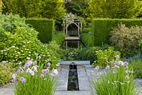 The Lower Rill Garden at Wollerton Old Hall Garden, Shropshire, planting includes Iris ensata, Hydrangeas, Geraniums, and Salvias