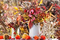 Autumn leaves and perennials in a jug: rosehips, asters, roses, Persicaria, dogwood, Physalis, Verbena bonariensis, Berberis, Solidago.