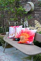 Cushion covers decorated with flower prints. Behind spikes of Digitalis alba, Aconitum napellus 'Album' and Rodgersia pinnata.