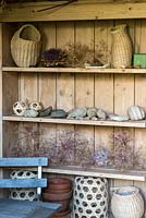 Shelves in a summerhouse hold large seedheads from Allium cristophii and Allium 'Purple Sensation'.