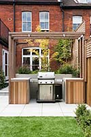 Outdoor cooking area and planting of: Salvia caradona, Buxus semperivens, Anemome japonica, Acer disectum, Astroturf, pleached hornbeam behind