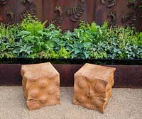 Two carved oak cube seats on gravel path, rusted steel fern wall panel, planting of ferns, hosta, Constraining Nature garden - designed by Kate Durr Garden Design - Best Festival Garden award and a gold medal - RHS Malvern spring festival 2015