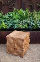 Carved oak cube wooden seats on gravel path, rusted steel fern wall panel, reflective water feature, planting of ferns, hosta, Constraining Nature garden - designed by Kate Durr Garden Design - Best Festival Garden award and a gold medal - RHS Malvern spring festival 2015