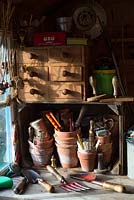 Traditional potting bench with an assortment of gardening items.