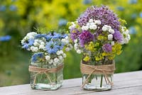 Summer cut flowers in glass jars decorated with string.