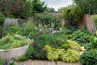 A small walled town garden - 50ft x 40ft mixed borders of flowers, vegetables and herbs, raised chamomile bed and patio seating area.