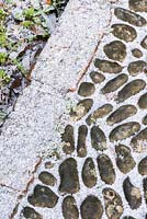 Pebble mosaic path thrown into relief by a dusting of snow.