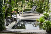 Small rectangular pond with cascade and wooden deck. Agapanthus orientalis White in pot. Family Fabry - Mathijs. Belgium