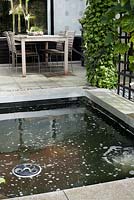 Paved patio with small pond and dining area. Family Fabry - Mathijs. Belgium