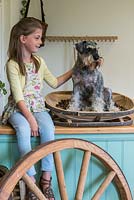 Orla Groves with Wurzel, a miniature Schnauzer, sitting in a willow dog basket made by Charlie Groves, maker of traditional Sussex trugs.