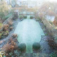 Aerial view of formal town garden in winter with box topiary, pleached field maples. 