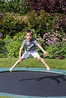 7-year-old Archie on the trampoline, set into the lawn.