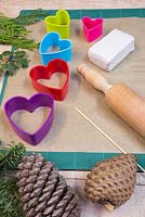 Materials required are a rolling pin, modelling clay, wooden skewer, heart shaped cutters and a variety of conifer foliage