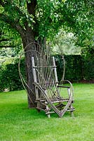 Woven willow chair in the orchard at the Prieuré Notre-Dame d'Orsan in June