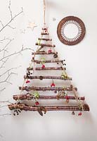 A hanging Christmas tree made with Birch branches. Decorations feature Pine cones, feathers, Rose hips and Ivy seed heads