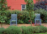 Two pale blue wooden rocking chairs behind a lavender border