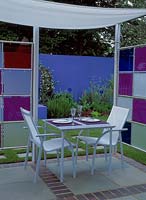 Metal furniture in garden room. Coloured perspex panels are used to create colourful walls. Design: Jane Mooney - A versatile garden for modern living. hcfs 2002