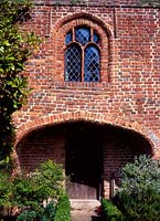 Sissinghurst Castle - the entrance court, brick house front with arch to door, July