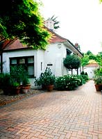 Bricked drive surrounding white house and container garden, Pembridge Cottage, Twickenham