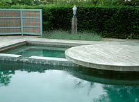 Chinese slate swimming pool with cantilevered deck, rush and wood screen, blue head sculpture by Patricia Volk, underplanted with Lavandula 'Sawyers'.