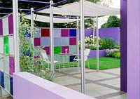 View to patio with metal furniture, perspex screen creates garden room. Design: Jane Mooney -  a versatile garden for modern living. HCFS 2002