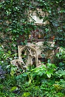 View of border in court yard garden with fire place. Hedera helix, Fatsia japonica and Asplenium scolopendrium, Lucille Lewins, small office court yard garden in Chiltern street studios, London. Designed by Adam Woolcott and Jonathan Smith