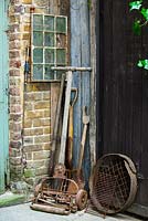 Corner of the court yard with old garden tools, Lucille Lewins, small office court yard garden in Chiltern street studios, London. Designed by Adam Woolcott and Jonathan Smith