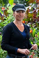 Liz Browne in the Edible Jungle at the Urban Jungle Nursery. Behind her is the a tamarillo, or tree tomato - Solanum betaceum