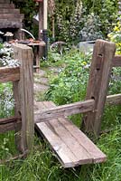 Wooden crossing over fence. 'Fenland Alchemist Garden', Designer: Stephen Hall and Jane Besser, Chelsea 2009