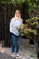 Portrait of the garden owner standing in a grove of black bamboo.