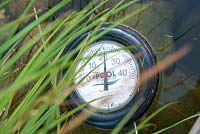 Water thermometer in pond. Small garden paradise in the city of zurich