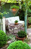 Seating area with lanterns, hanging basket, Buxus with rustic table and chairs