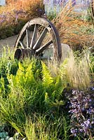 Old cart wheel amongst Polystichum polyblepharum, Stipa tenuissima and Polemonium 'Heaven Scent' -  The Low Line, RHS Malvern Spring Festival 2016