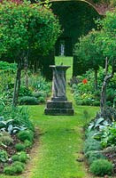 Standard honeysuckles surround a sundial at the centre of the Herb Garden at Cranborne Manor Garden, Dorset in spring
