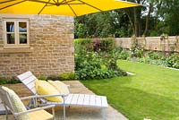 The patio with parasol and reclining chairs