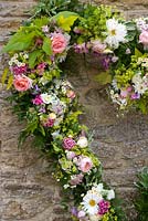 Floral wreath made from fresh flowers picked from the garden - roses, sweet william and golden hop. Common Farm Flowers, Somerset

