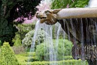 Mitton Manor Garden in spring, Staffordshire. Splashing water feature in formal garden