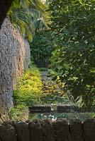A cascading stone waterway feeds water drawn from a deep well into the arabic garden. San Giuliano Estate. Sicily, Italy