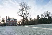 A frosty lawn spreads out from the early C18th facade of Welford House. Welford Park, Newbury, Berks, UK