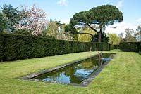 Long narrow pond with sculptured water fountain - Dunsborough Park Gardens, Ripley, Surrey