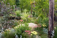 Great Gardens of the USA: The Austin Garden, View of garden including corten steel water feature which creates a focal point surrounded by variegated yuccas, purple katsura tree - Cercidiphyllum japonicum, Achillea 'Summer Fruits Lemon', Achillea 'Summer Fruits Carmine', Anthermis tinctiria 'E C Buxton', Stachys byzantina, echinaceas, and a mist of Stipa tenuissima blowing in the breeze. RHS Hampton Court Flower Show in 2016