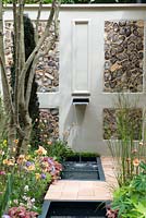 Water feature with pebble panelled wall. Pro Corda Trust - A Suffolk Retreat, RHS Chelsea Flower Show 2016 - Design: Frederic Whyte, Sponsor: Pro Corda Trust