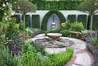 The St John's Hospice - A Modern Apothecary Courtyard garden with stone and brick paving, borders of herbal and healing plants and central water feature pool. RHS Chelsea Flower Show 2016 - Designer: Jekka McVicar, Sponsor: St John's Hospice