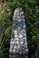 Flint sculpture in a reflecting pool, Taxus baccata hedge behind - Streetscape's Summer in Sussex, Design: Gary Price, RHS Hampton Court Palace Flower Show 2016