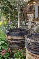 The RHS Greening Grey Britain garden with woven willow compost bins, insect hotels and foxgloves. RHS Chelsea Flower Show 2016, Designer: Ann Marie Powell - Sponsor: The RHS