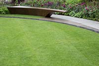 The Chelsea Barracks Garden, view of bronze bench, lawn, Basaltite stone path Rosa 'Nuits de Young'. RHS Chelsea Flower Show 2016, Designer: Jo Thompson, Sponsor: Quatari Diar