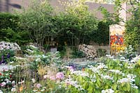Stained glass panel, Stipa gigantea and Viburnum plicatum f. tomentosum 'Mariesii' in foreground, God's Own County - A Garden for Yorkshire, RHS Chelsea Flower Show 2016, Designer: Matthew Wilson, Sponsor: Welcome to Yorkshire