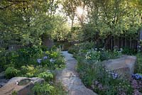 The M and G Garden - view of garden path made from Forest of Dean sandstone with stone boulders at sunrise. RHS Chelsea Flower Show, 2016 Designer: Cleve West MSGD, Sponsor: M and G 