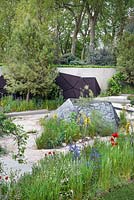 The Royal Bank of Canada Garden. Dry Mediterranean influenced garden with stone features, gravel paths, planting including Asphodeline lutea, Pinus halepensis, Papaver rhoeas and Rosa canina. The RHS Chelsea Flower Show 2016, Designer: Hugo Bugg, Sponsor: Royal Bank of Canada. 